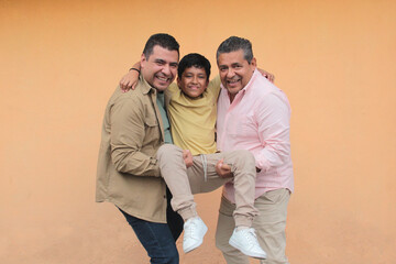 Three generations of a dark-skinned Latino grandfather, father, and son show their love and spend time together to celebrate Father's Day