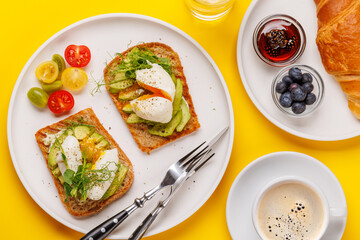 Breakfast with delicious avocado toasts and crispy croissant
