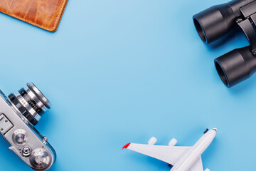 Travel-themed flat lay with toy airplane, camera, and passport