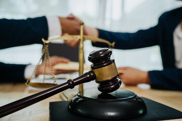 A lawyer consulting with a client in an office, reviewing legal documents and contracts related to justice, law, and business.