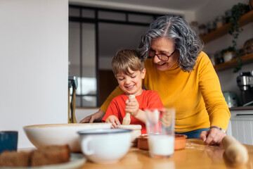 Grandmother and grandson baking together in the kitchen