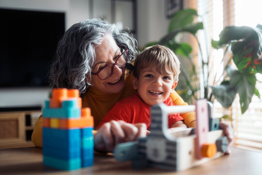 Grandmother and grandson playing with building blocks at home