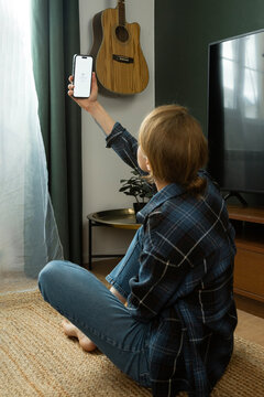 Woman searching for internet signal holding smartphone in living room