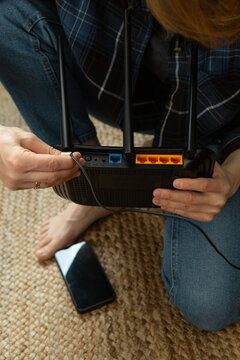 Woman connecting cable to wifi router for better