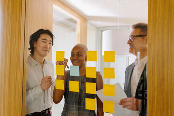 Businesspeople using sticky notes during brainstorming session