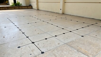 Tile floor with black grid lines marked for construction work, illustrating layout planning, structure, and architectural groundwork.