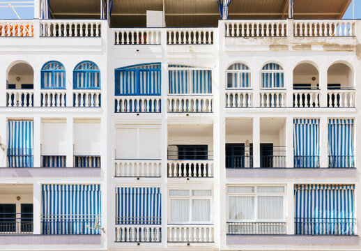 Facade with blue and white striped awnings and arches