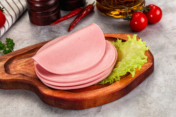 Sliced boiled sausage over board