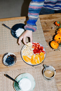 Shot lit with flash of an unknown hand grabbing a slice of banana