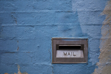 Close Up of Blue Brick Wall with Metal Mail Slot
