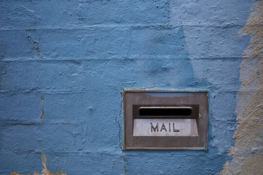 Close Up of Blue Brick Wall with Metal Mail Slot