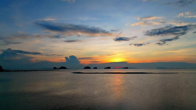 Landscape view with Sunset as breaking through the dark clouds over ocean sea as water wave in the island as dawn sky scene