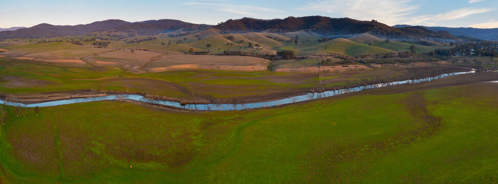 Narrow stream flowing htrough green mountain valley