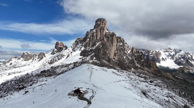 Cinematic drone shot pulling away from Ra Gusela and winter landscape at Passo Giau