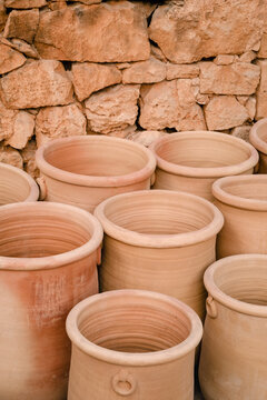 Large terracotta urns against a dry stone wall 