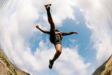Wide, low angle shot of a trail runner taking a long stride