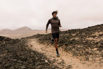A sportsman trains hiking along a pebbled path