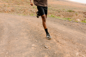 Unknown person running fast on a gravel path