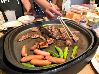 焼肉をホットプレートで焼く　家族の夕食シーン