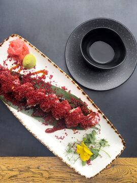 Sushi rolls, ginger, wasabi and a bowl with soya sauce on a table