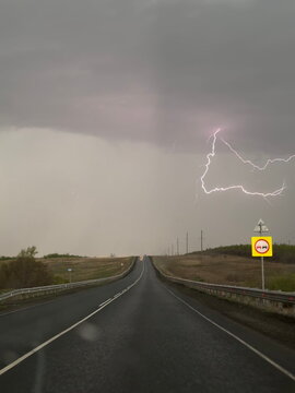 Lightning strike above empty highway at dusk