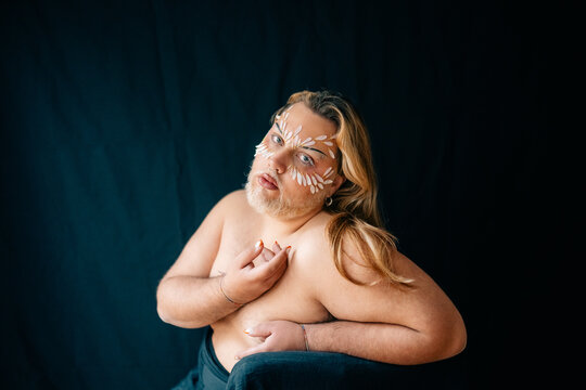Expressive portrait of person with artistic face paint and long hair