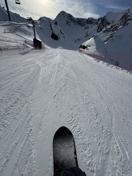 Snowboard ride down ski slope point of view