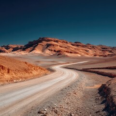 Fototapeta premium Dusty road winds through ochre desert hills under a vibrant sky