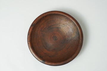 A round clay plate made of earthenware with a rustic brown texture. Ideal for traditional food styling, natural themes, or Indonesian kitchen decor.