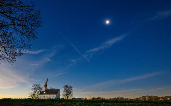 Total solar eclipse over a church in the country.