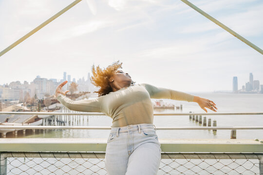 Woman arches gracefully against New York waterfront skyline