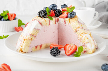 Charlotte Royale Cake with strawberry cream inside and decorated fresh berries. Delicious summer cake.