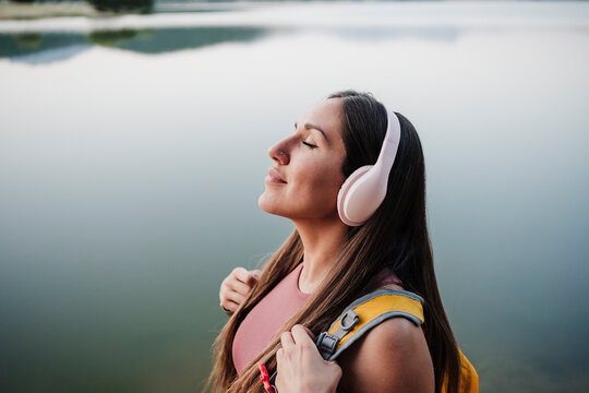 Female hiker with eyes closed standing at lakeshore