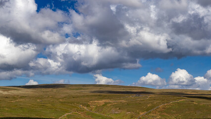 Remote stone barn beneath dramatic clouds on moorland in the Yorkshire Dales, England
