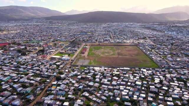 Wide aerial descent with view over vast squatter camp township in South Africa