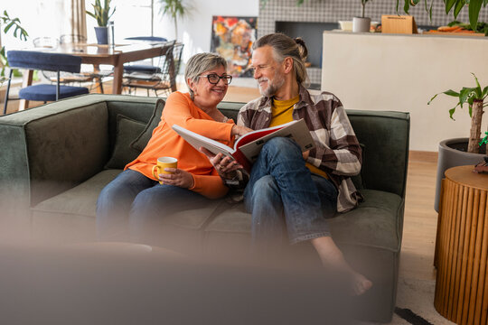 Senior couple enjoying a catalog on the sofa in their living room