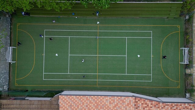 Children playing five-a-side football and having fun playing an after-school football match - fun and sports during childhood - drone footage of a football sports centre