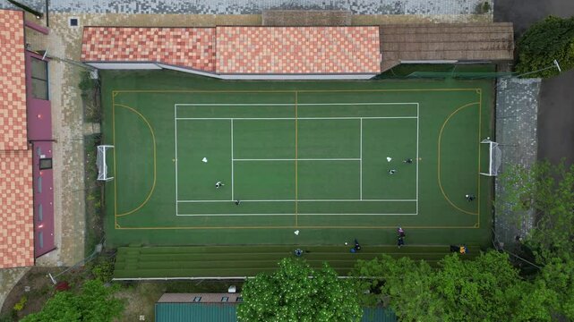 Children playing five-a-side football and having fun playing an after-school football match - fun and sports during childhood - drone footage of a football sports centre