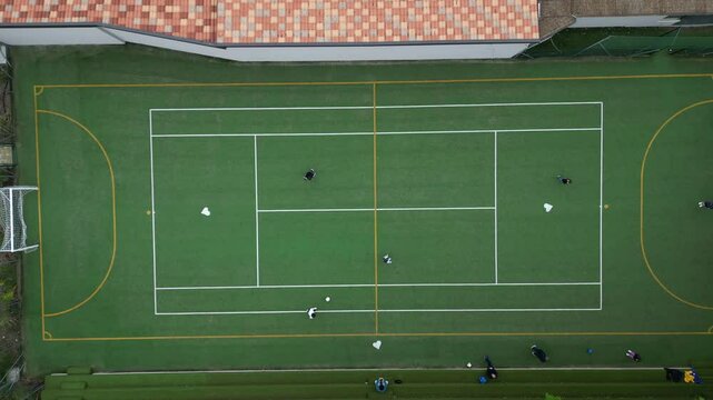 Children playing five-a-side football and having fun playing an after-school football match - fun and sports during childhood - drone footage of a football sports centre