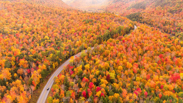 Aerial view of a scenic drive through the colorful autumn foliage in Wilmington Notch, Adirondacks, New York.