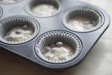 ブルーベリーマフィンの生地をマフィンの型に流し入れてオーブンで焼く直前。手作りブルーベリーマフィンを作る工程