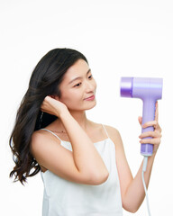 Asian girl using hair dryer