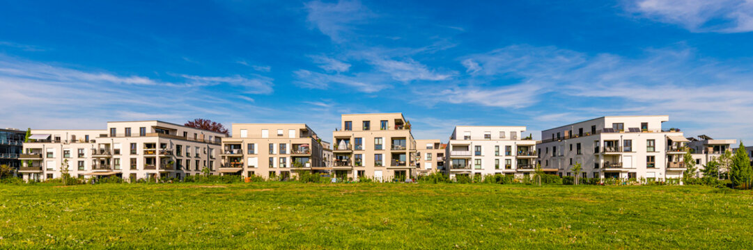 Modern apartment buildings in Fellbach, Germany with green space and blue sky - Powered by Adobe