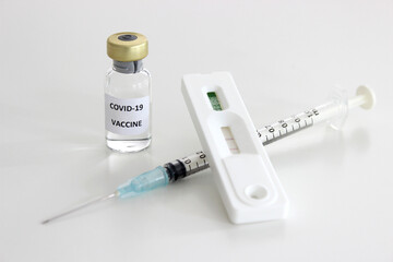 Vial of Covid-19 vaccine, 1 ml plastic syringe with needle and Positive test result of Covid-19 antigen test kit isolated on the white background