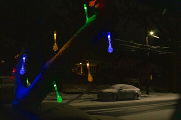 snowy city street with colorful lights