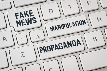 White keyboard with keys labeled with terms like 'Lies', 'Hoax', and 'Disinform', representing the spread of misleading online content.