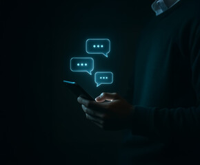 Man using smartphone with glowing floating chat bubbles, depicting virtual conversation, tech usage, and online connectivity.