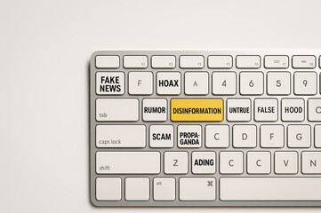 Close-up of computer keyboard with themed keys warning of misinformation, featuring bold text like 'Clickbait' and 'Lies'.