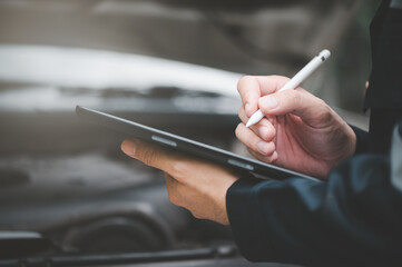 Car Engine Service Concept, Car Mechanic Writing Checklist on Digital Tablet for Machinery Repair, Car Service and Maintenance.