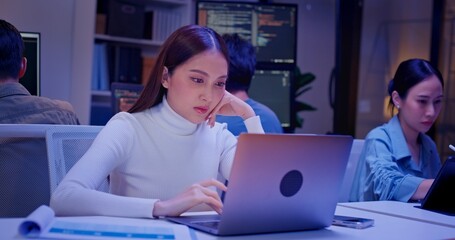 Diverse AI engineers working late in high-tech office, coding algorithms, analyzing data, and building intelligent systems. Focused teamwork and innovation drive future-ready software development.